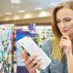 Young woman reading label milk