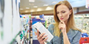 Young woman reading label milk